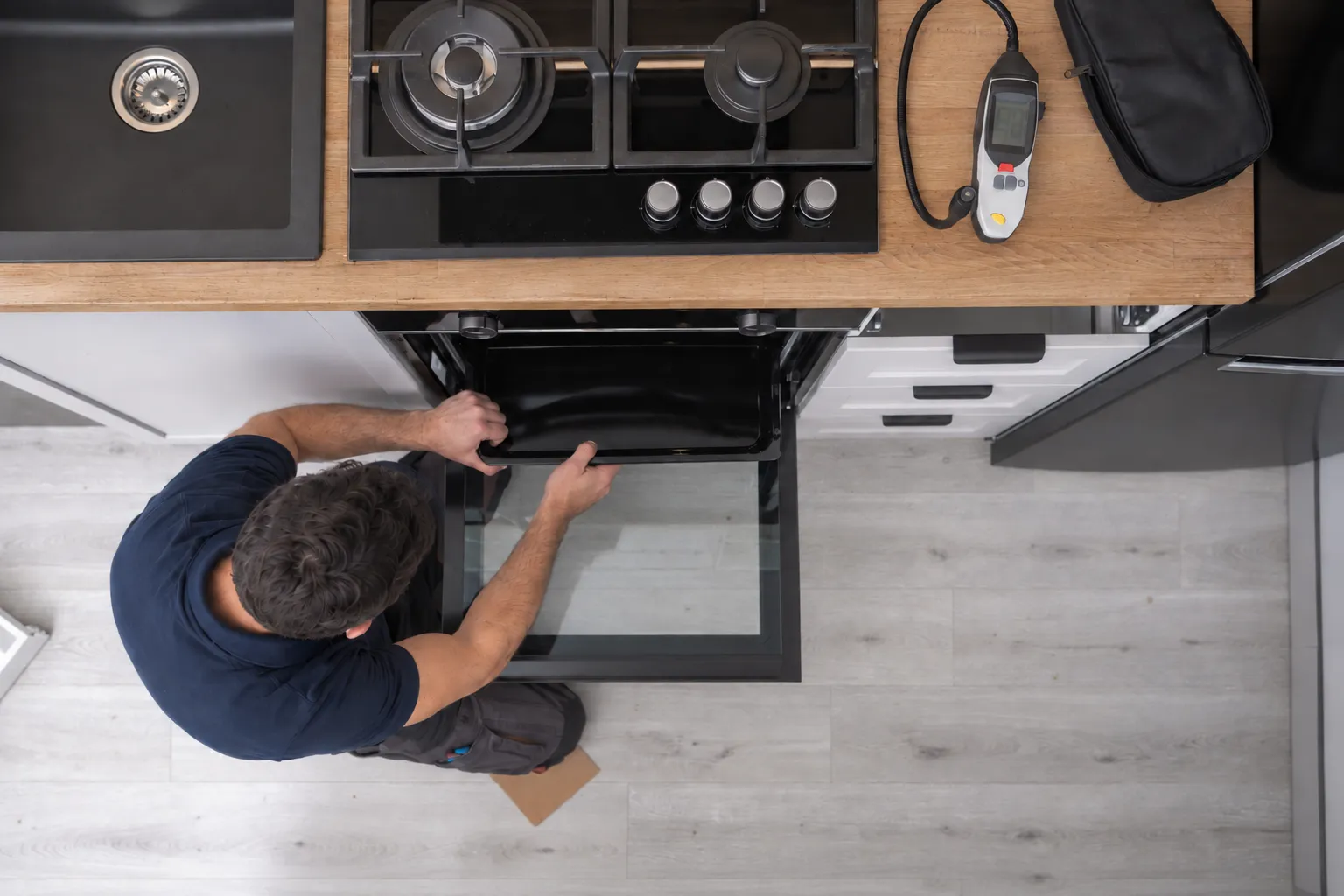 A MyBosch technician inspecting an under-bench oven